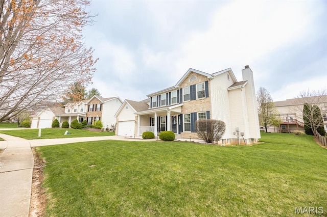 view of front of property featuring a chimney, driveway, a front yard, and covered porch