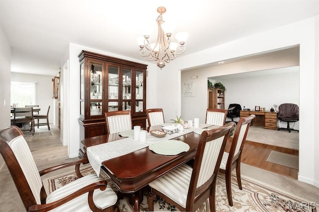dining room with a chandelier and light wood finished floors