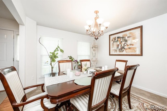 dining room featuring a chandelier, healthy amount of natural light, and baseboards