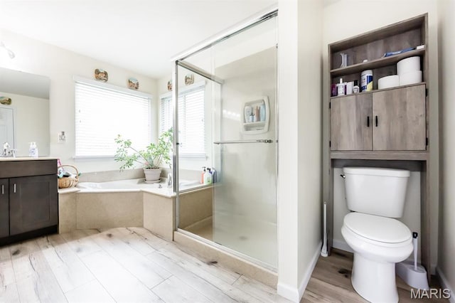 bathroom with a stall shower, a bath, toilet, wood finished floors, and vanity