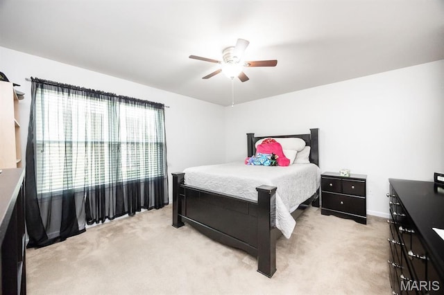 bedroom with light colored carpet, a ceiling fan, and baseboards