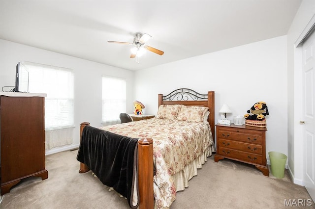 bedroom featuring light carpet, ceiling fan, and baseboards