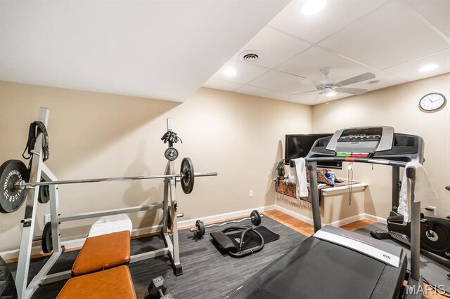 workout room with baseboards, a ceiling fan, and a drop ceiling