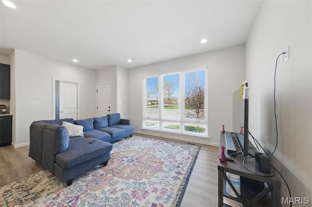living room featuring light wood finished floors, recessed lighting, and baseboards