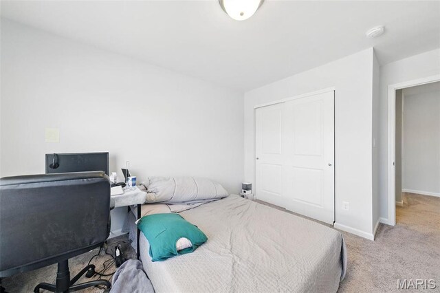 bedroom with carpet flooring, baseboards, and a closet
