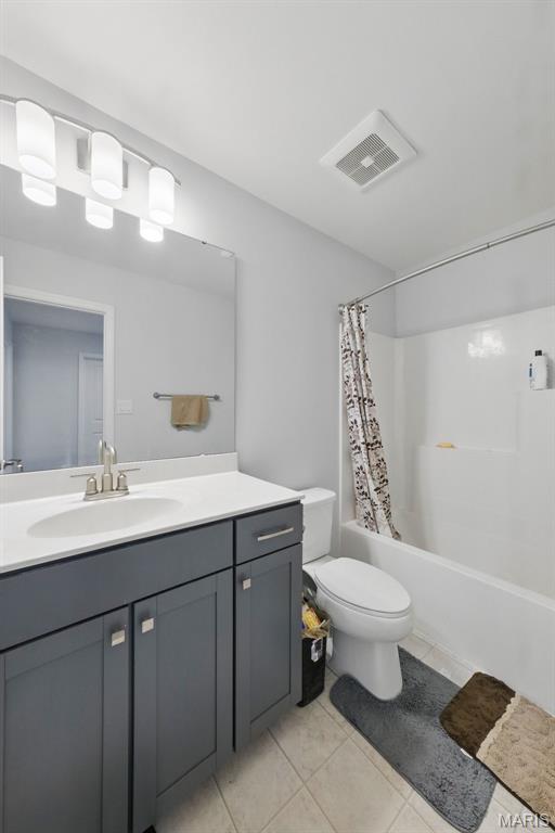 full bath featuring toilet, shower / tub combo, vanity, and tile patterned floors