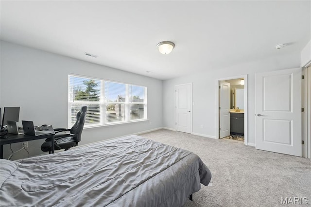 carpeted bedroom featuring baseboards and ensuite bathroom