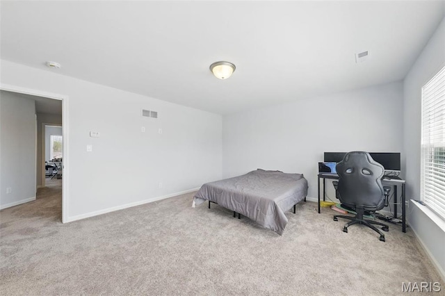 carpeted bedroom featuring a desk and baseboards