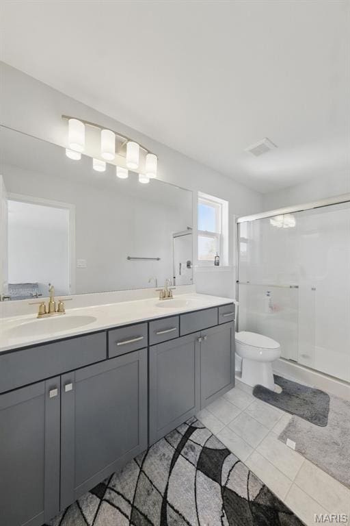 full bath with double vanity, a shower stall, toilet, and tile patterned floors