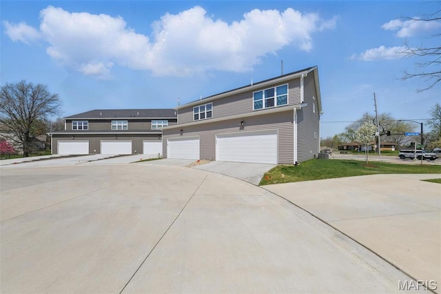 multi unit property featuring driveway and a garage
