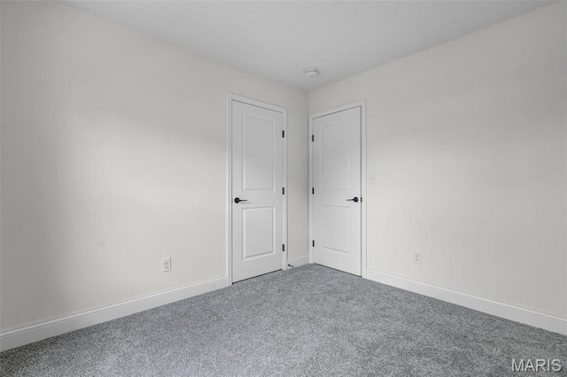 carpeted empty room featuring baseboards