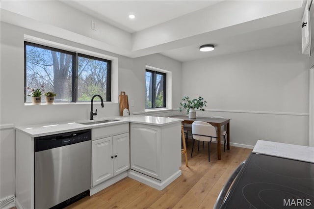 4410 Robbins Mill Rd, Florissant, MO 63034 - kitchen featuring stainless steel dishwasher, plenty of natural light, a sink, light wood-style floors, and recessed lighting