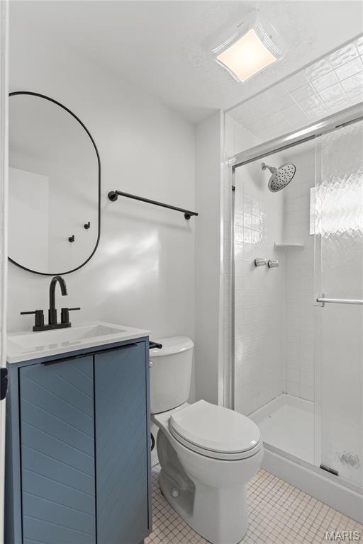 4410 Robbins Mill Rd, Florissant, MO 63034 - bathroom with tile patterned flooring, toilet, a stall shower, and vanity
