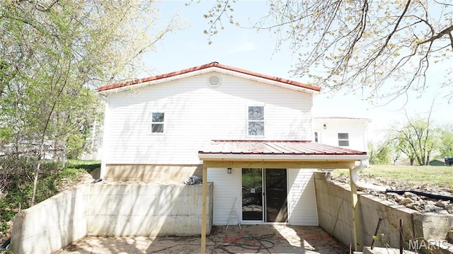 rear view of property with metal roof