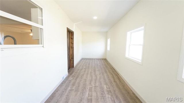 hallway featuring wood finished floors and baseboards