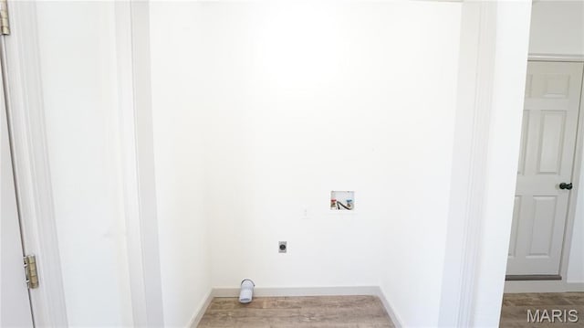 laundry area featuring electric dryer hookup, hookup for a washing machine, wood finished floors, and baseboards