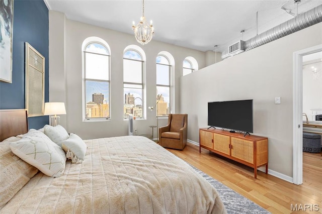 bedroom with wood finished floors, a chandelier, and baseboards