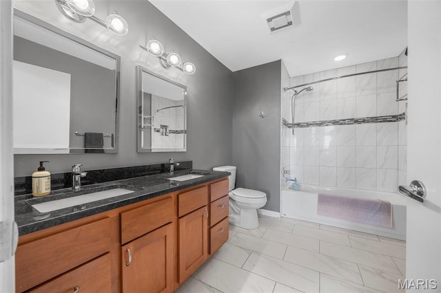 full bath with marble finish flooring, shower / bath combination, double vanity, and toilet