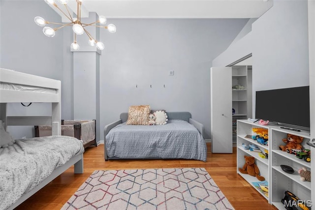 bedroom with a chandelier, wood finished floors, and baseboards
