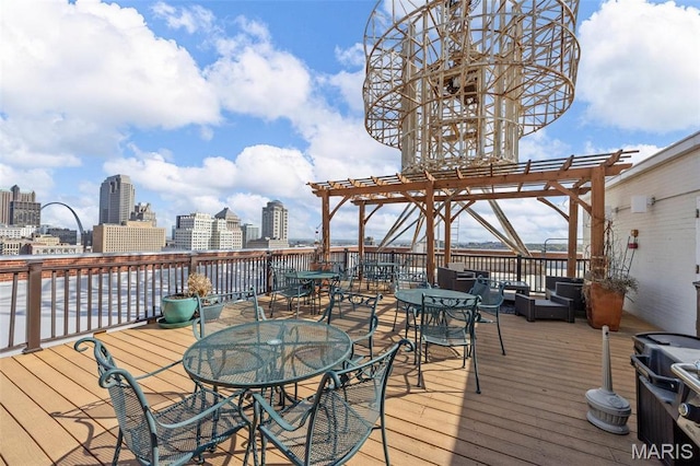 wooden terrace with a pergola, outdoor dining space, and a city view