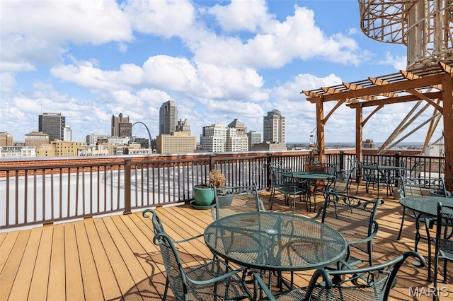 wooden terrace featuring outdoor dining area, a skyline view, and a pergola