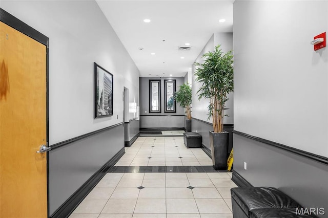 corridor featuring light tile patterned floors, baseboards, and recessed lighting
