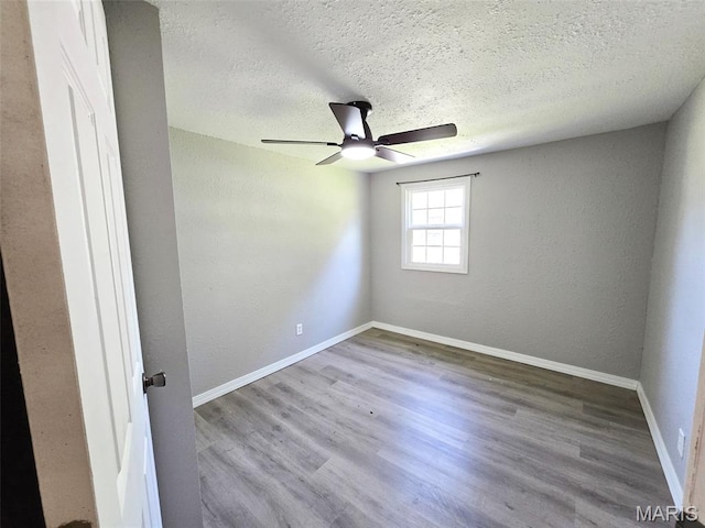 828 W Elk St, Dexter, MO 63841 - spare room with a textured ceiling, ceiling fan, wood finished floors, and baseboards