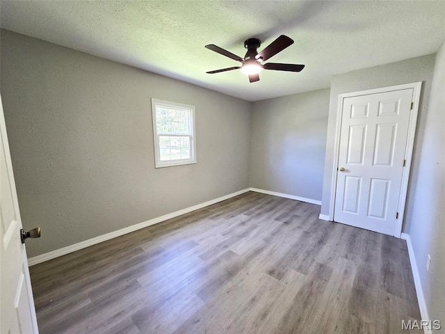 828 W Elk St, Dexter, MO 63841 - unfurnished bedroom with wood finished floors, baseboards, a textured ceiling, and a ceiling fan