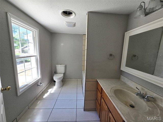 828 W Elk St, Dexter, MO 63841 - bathroom with vanity, plenty of natural light, toilet, a textured ceiling, and a tub to relax in