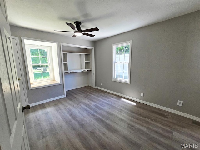 828 W Elk St, Dexter, MO 63841 - unfurnished bedroom featuring dark wood-type flooring, baseboards, and a ceiling fan