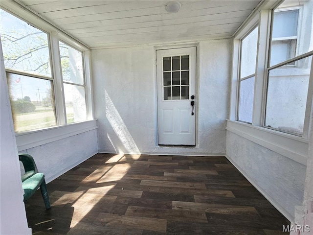 unfurnished sunroom with wooden ceiling, wood finished floors, and a textured wall