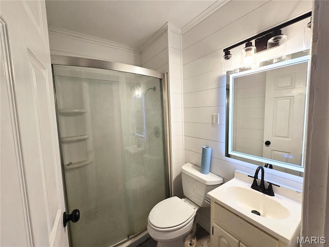 bathroom with crown molding, a shower stall, toilet, and vanity
