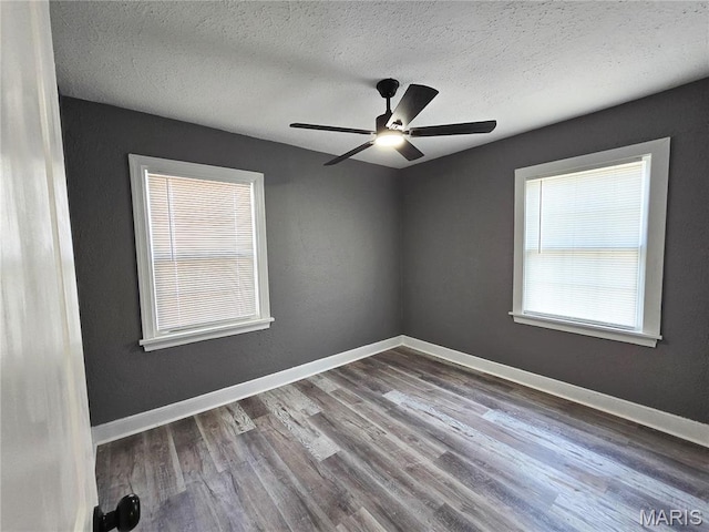 unfurnished room with wood finished floors, a textured ceiling, a ceiling fan, and baseboards