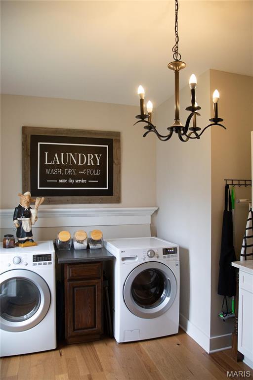 3 Inland Ct, Wright City, MO 63390 - laundry area with washer / dryer, cabinet space, light wood finished floors, and a chandelier