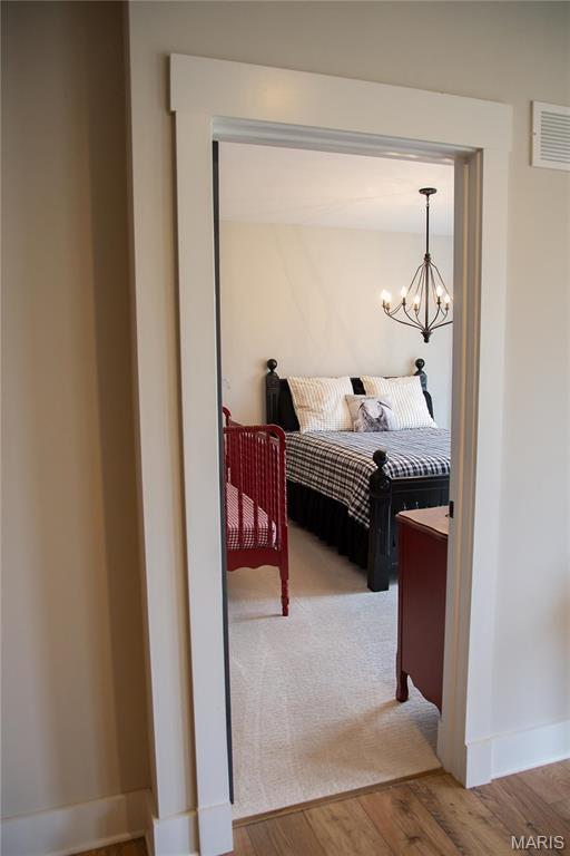 3 Inland Ct, Wright City, MO 63390 - bedroom with a chandelier, wood finished floors, and baseboards