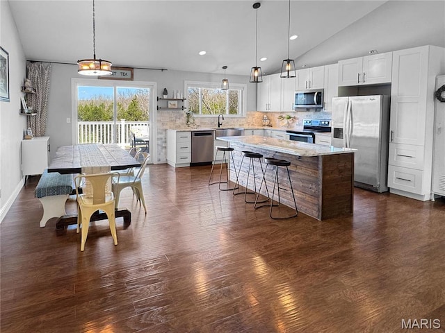 641 Ponderosa Trl, Beaufort, MO 63013 - kitchen with stainless steel appliances, dark wood-style flooring, vaulted ceiling, tasteful backsplash, and white cabinets