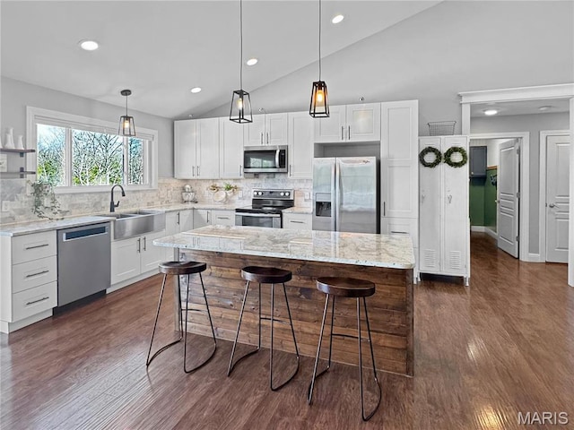 641 Ponderosa Trl, Beaufort, MO 63013 - kitchen featuring stainless steel appliances, a sink, vaulted ceiling, a kitchen bar, and white cabinetry