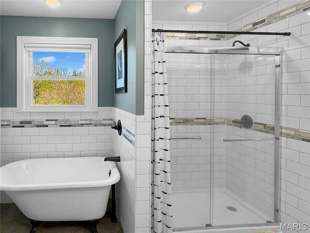 641 Ponderosa Trl, Beaufort, MO 63013 - bathroom featuring a stall shower, tile walls, a freestanding tub, and wainscoting