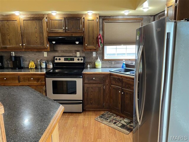 10303 Woodberry Rd, Potosi, MO 63664 - kitchen with stainless steel appliances, exhaust hood, backsplash, a sink, and light wood-style floors