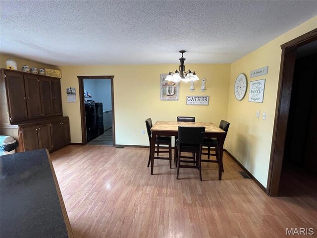 10303 Woodberry Rd, Potosi, MO 63664 - dining space featuring independent washer and dryer, light wood finished floors, a textured ceiling, a chandelier, and baseboards