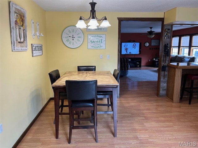 10303 Woodberry Rd, Potosi, MO 63664 - dining room with light wood-style floors, a chandelier, ceiling fan, and baseboards