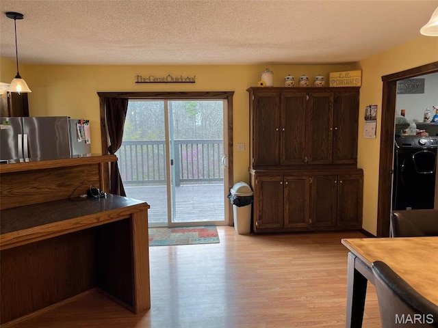 10303 Woodberry Rd, Potosi, MO 63664 - dining area with light wood-style flooring, a textured ceiling, and washer and dryer