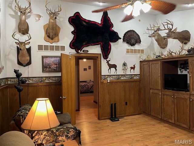 10303 Woodberry Rd, Potosi, MO 63664 - living area featuring light wood-style floors, a wainscoted wall, and ceiling fan