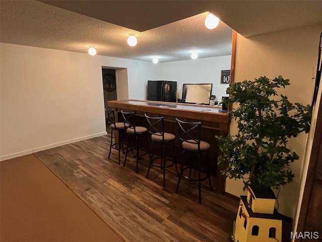 10303 Woodberry Rd, Potosi, MO 63664 - indoor dry bar with freestanding refrigerator, a textured ceiling, dark wood finished floors, and baseboards