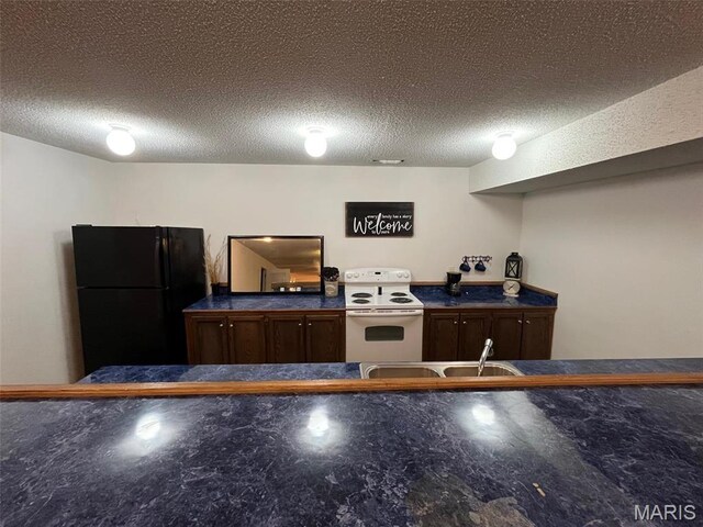 10303 Woodberry Rd, Potosi, MO 63664 - kitchen with white electric stove, freestanding refrigerator, dark countertops, and a textured ceiling