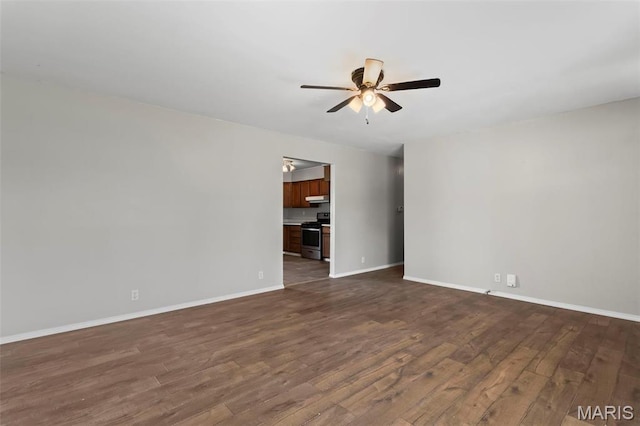 1112 N Illinois Ave, Litchfield, IL 62056 - unfurnished room featuring ceiling fan, dark wood-style floors, and baseboards