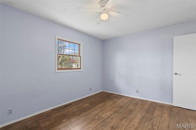 1112 N Illinois Ave, Litchfield, IL 62056 - spare room with wood finished floors, ceiling fan, and baseboards