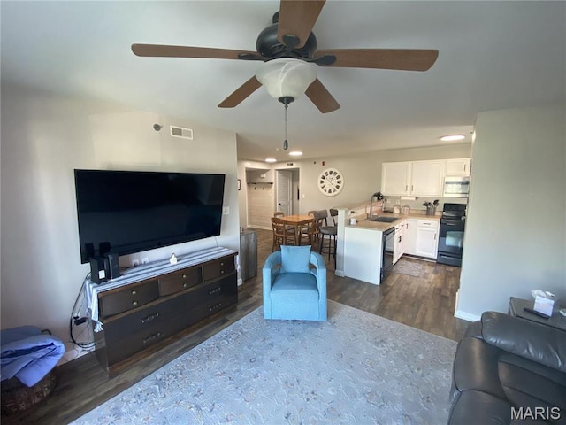 living room with dark wood-style flooring, a ceiling fan, and recessed lighting