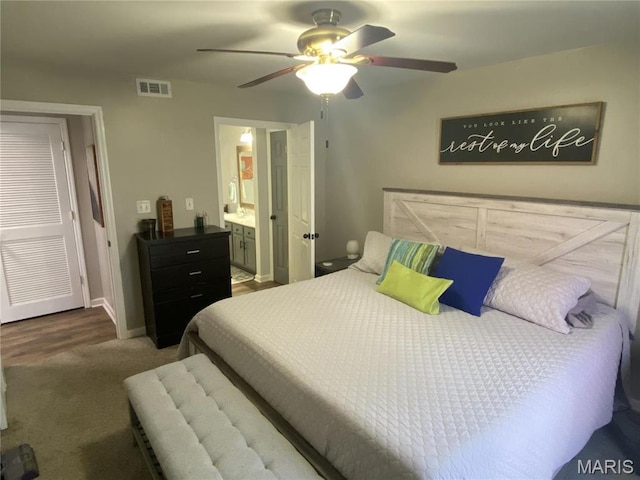 carpeted bedroom featuring baseboards, ceiling fan, and ensuite bath