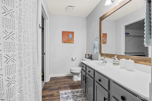 full bathroom featuring wood finished floors, vanity, toilet, baseboards, and a shower with shower curtain